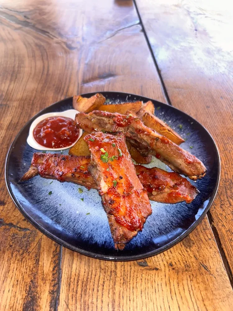 Côtes levées et pommes de terre sur assiette, sauce tomate.