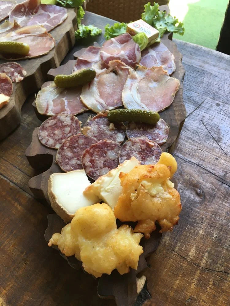 Plateau de charcuterie avec fromages et cornichons.