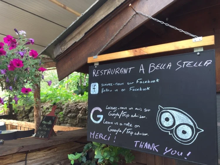 Tableau d'annonce de restaurant avec des fleurs.