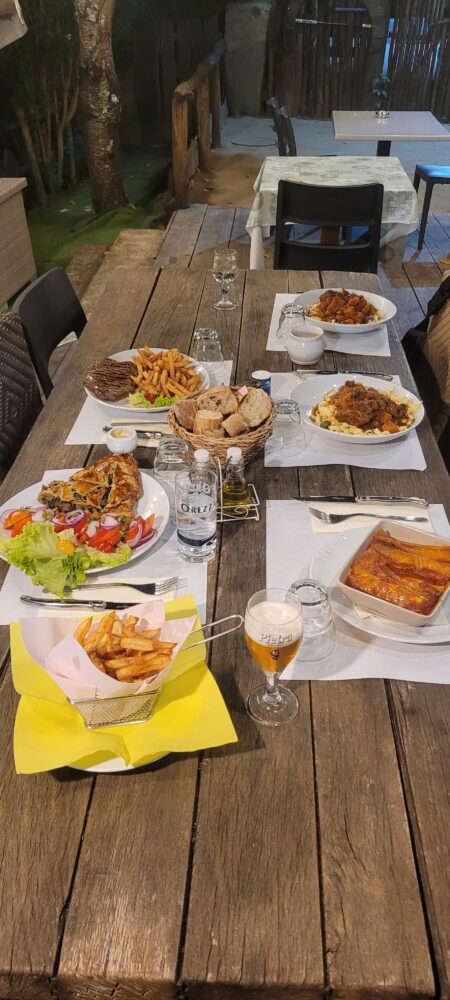 Table de restaurant extérieur avec plats variés.