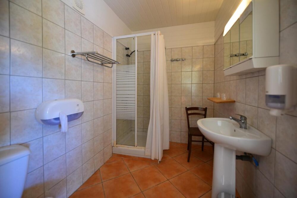 Salle de bain avec douche et lavabo.