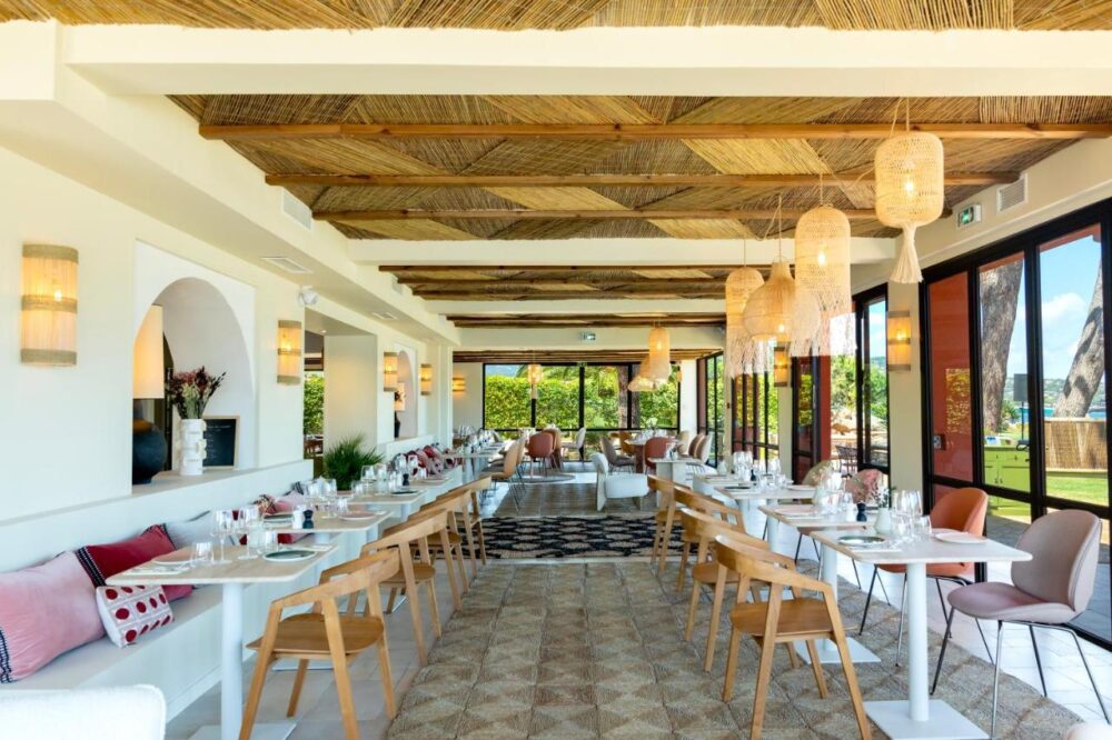 Restaurant lumineux avec tables et chaises élégantes.