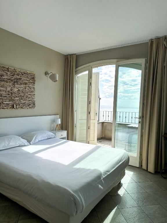 Chambre lumineuse avec vue mer et balcon.