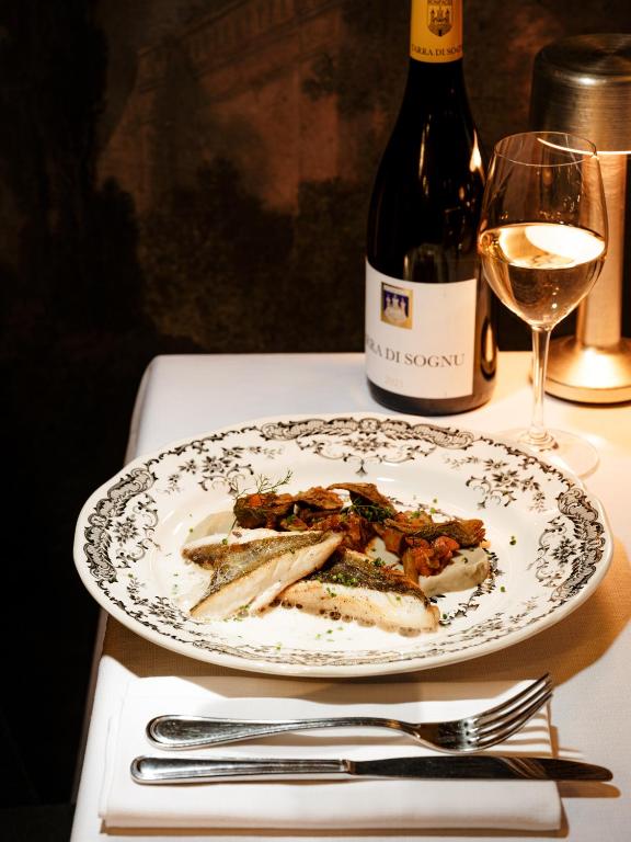 Plat de poisson avec vin blanc sur table.