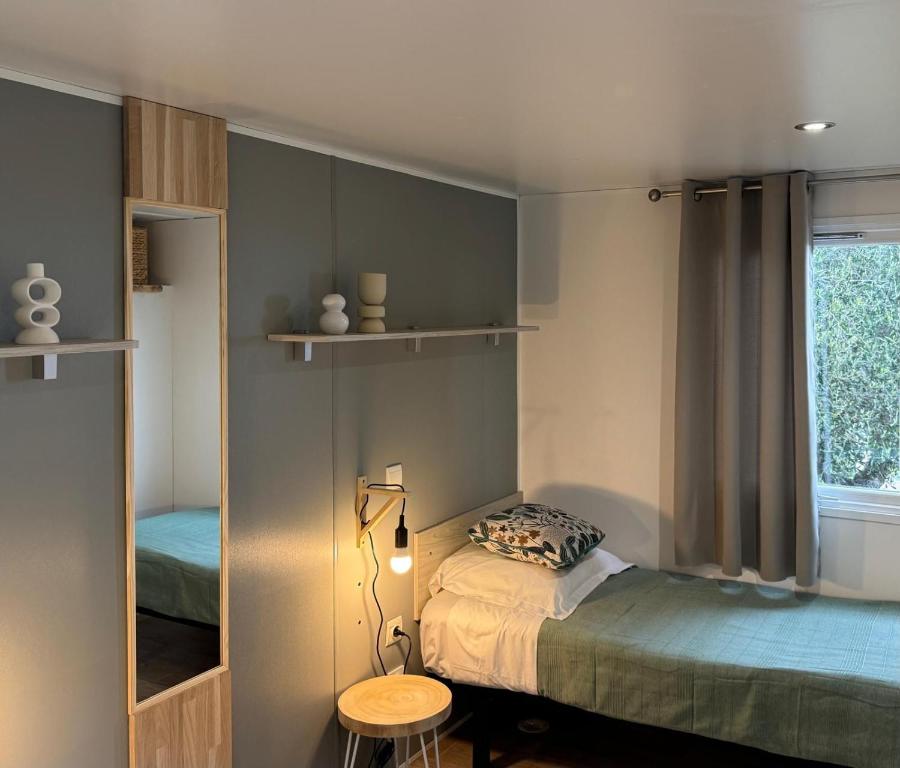 Chambre moderne avec lit simple et miroir.