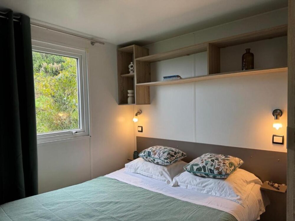 Chambre moderne avec lit double et étagères murales.