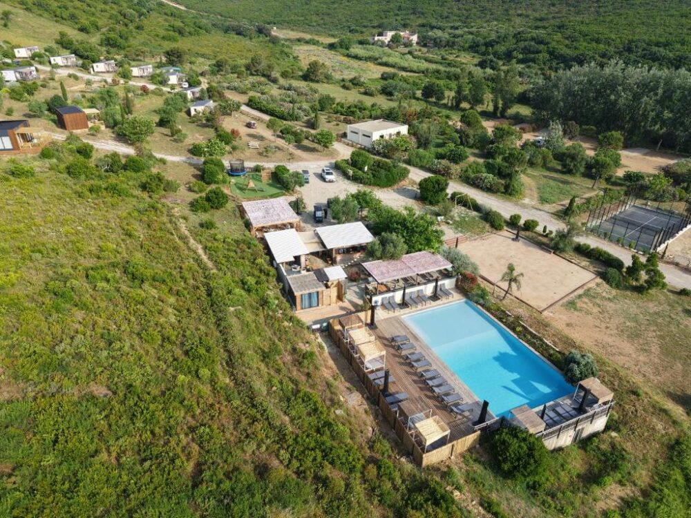 Vue aérienne complexe avec piscine et terrains.