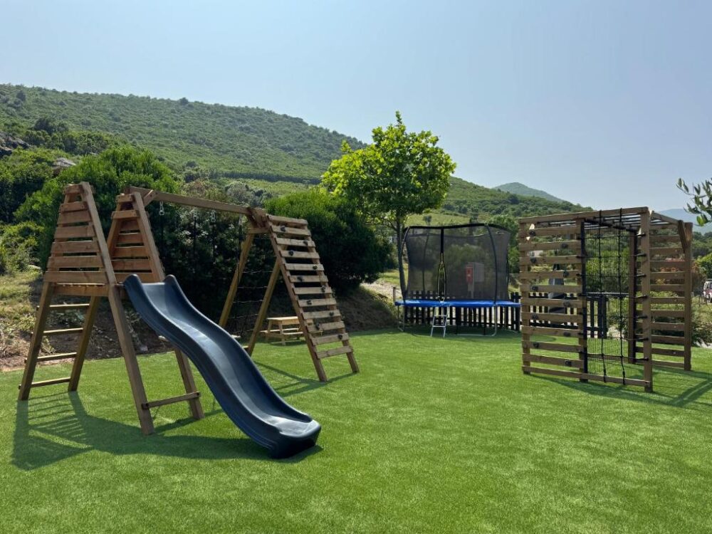 Aire de jeux extérieure avec toboggan et trampoline.