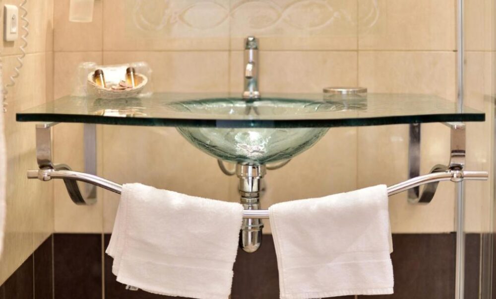 Lavabo moderne en verre avec serviettes blanches