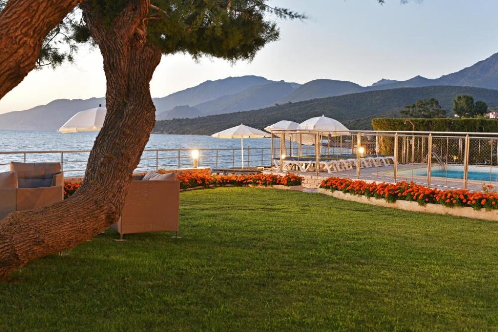 Jardin au bord de la mer avec piscine.