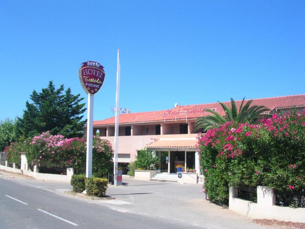 Façade d’un hôtel méditerranéen avec palmiers et fleurs