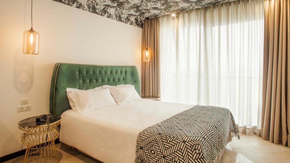 Chambre d'hôtel moderne avec lit double et rideaux.