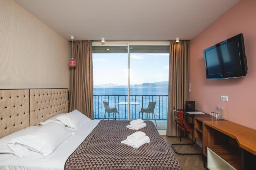 Chambre d'hôtel avec vue sur mer et balcon.