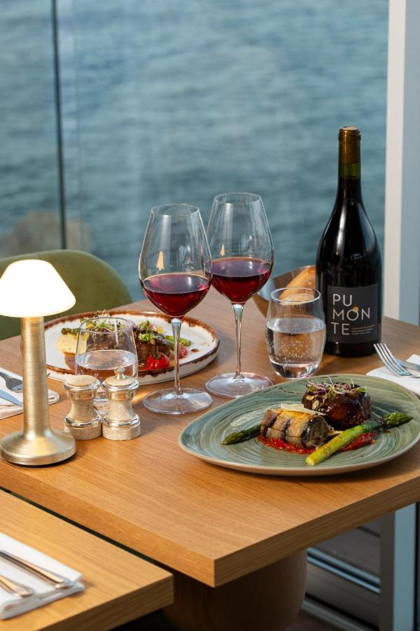 Dîner gastronomique avec vin rouge en bord de mer.