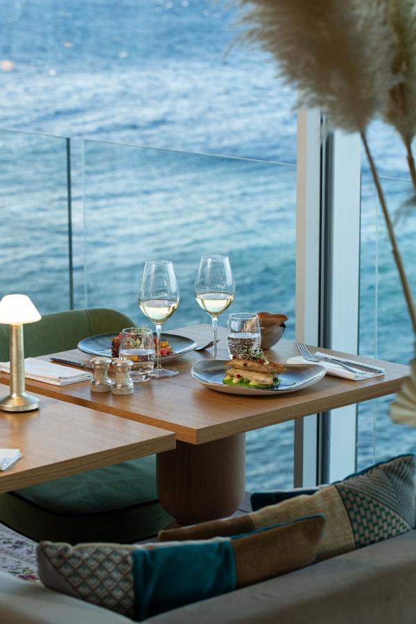 Table avec deux assiettes et vue sur la mer.