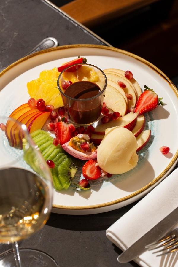 Assiette de fruits avec chocolat au centre.