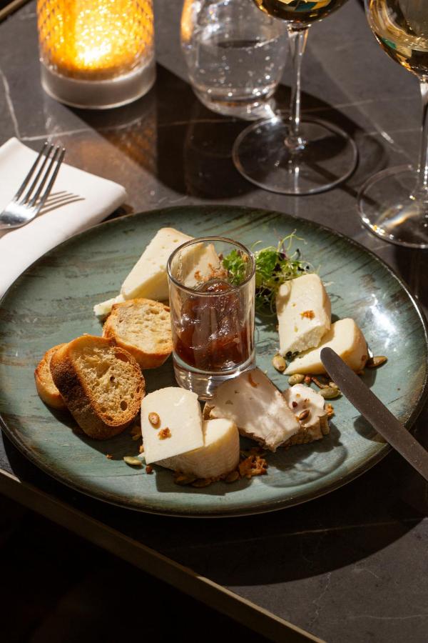 Assiette de fromages avec pain et condiments.