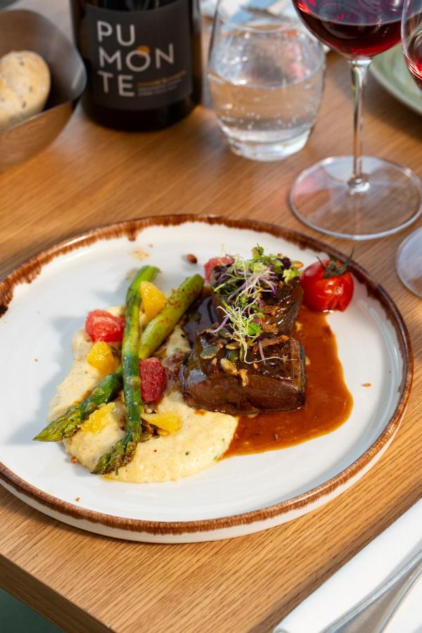 Assiette de viande sauce, légumes et verre de vin.
