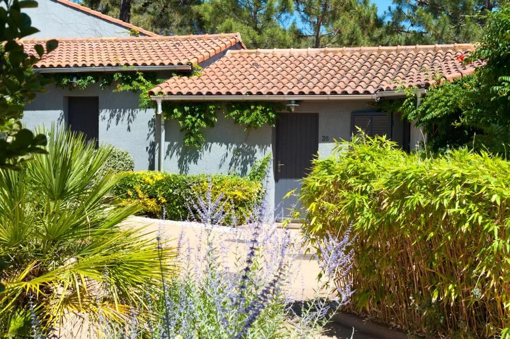 Maison avec jardin et toit en tuiles.