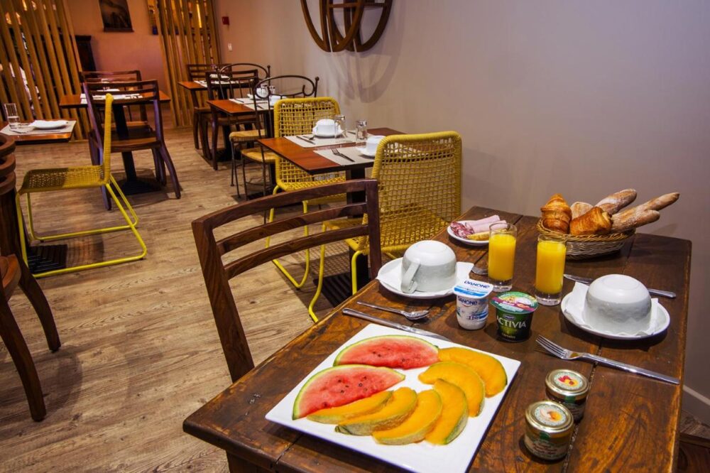 Petit-déjeuner avec fruits et viennoiseries en salle.
