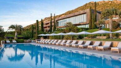 Piscine luxueuse avec chaises longues et parasols.
