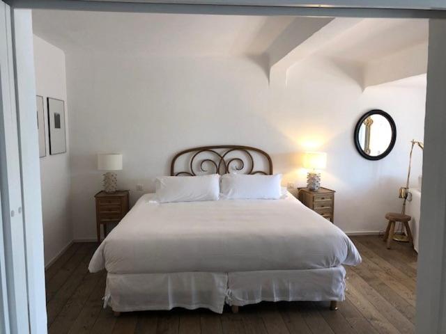 Chambre lumineuse avec grand lit blanc.