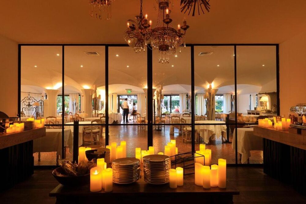 Restaurant élégant avec chandelles et tables dressées.