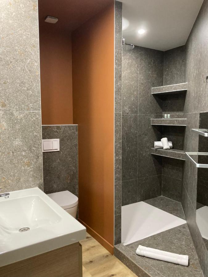 Salle de bain moderne avec douche italienne et lavabo.