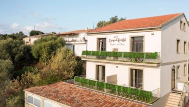 Auberge moderne entourée d'arbres, ciel bleu.