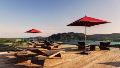 Terrasse avec chaises longues et parasols rouges.