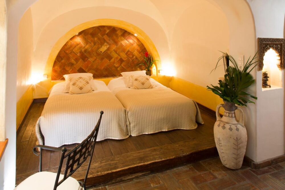 Chambre avec lits jumeaux et décorations rustiques.
