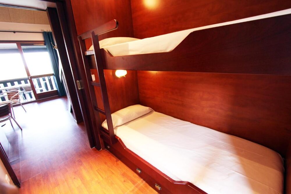 Lit superposé en bois dans une chambre lumineuse.
