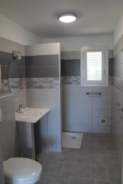 Salle de bain moderne avec douche et lavabo.