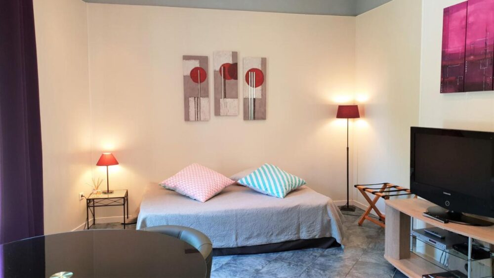 Salon moderne avec canapé et télévision.