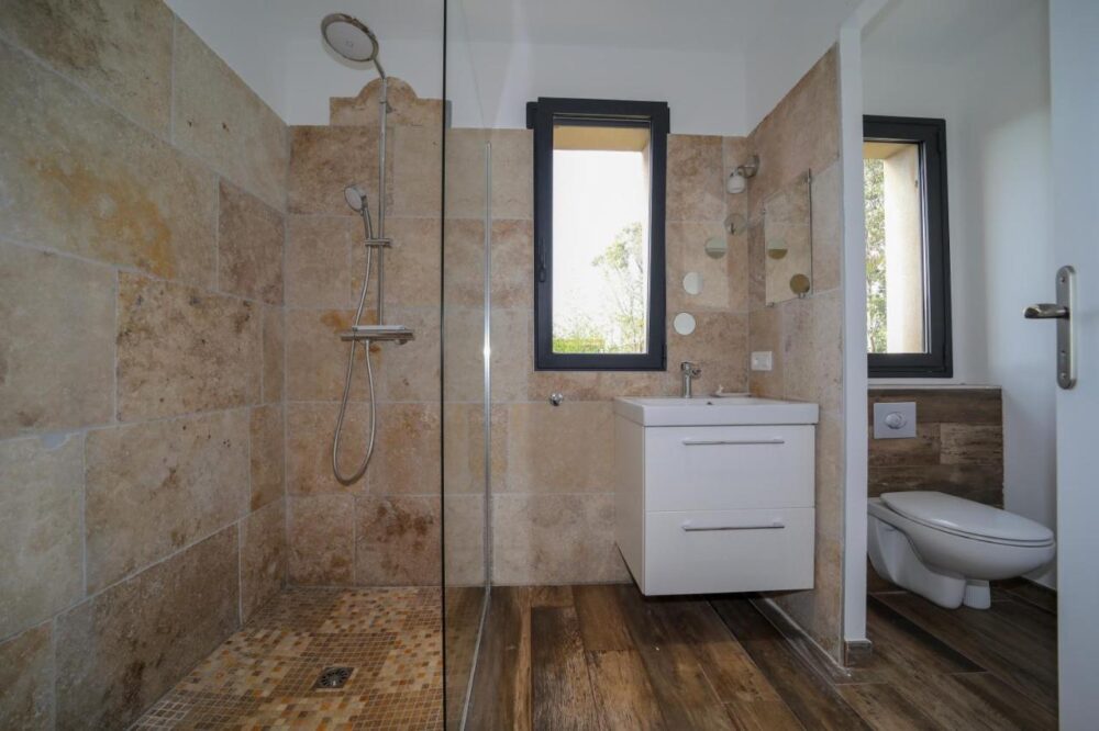 Salle de bain moderne avec douche et lavabo.