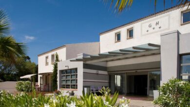 Entrée d'un hôtel moderne entouré de végétation.