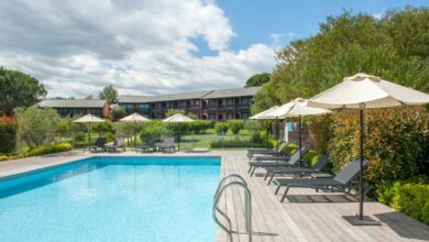 Piscine extérieure avec chaises longues et parasols.