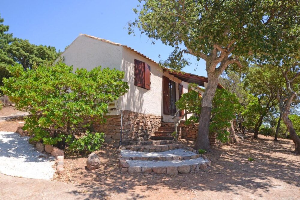 Maison en pierre entourée d'arbres.