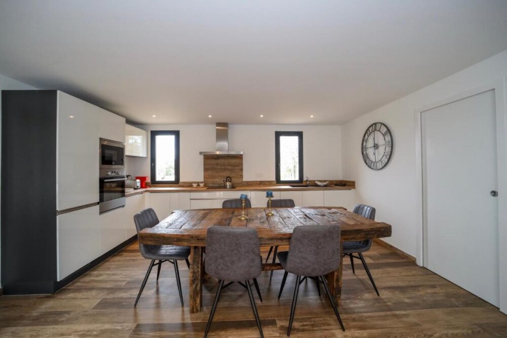 Cuisine moderne avec table en bois et chaises.