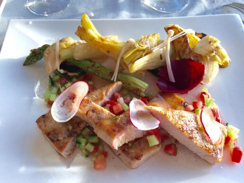 Plat coloré avec viande et légumes grillés.