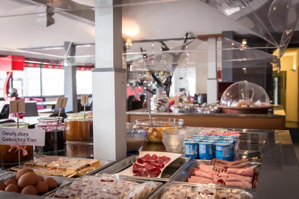 Buffet petit-déjeuner varié avec charcuterie et confitures.