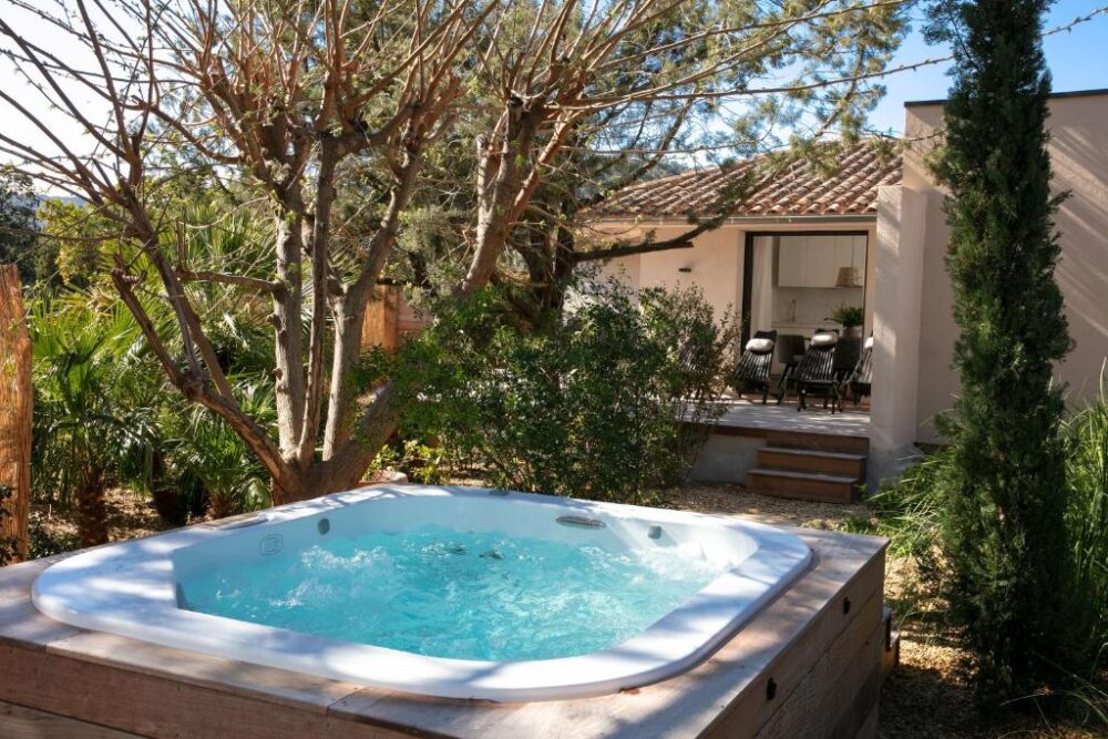 Jacuzzi extérieur près d'une maison accueillante.