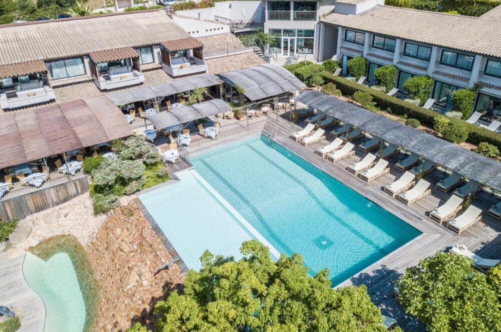Hôtel avec piscine extérieure et chaises longues.