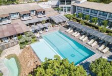 Hôtel avec piscine extérieure et chaises longues.