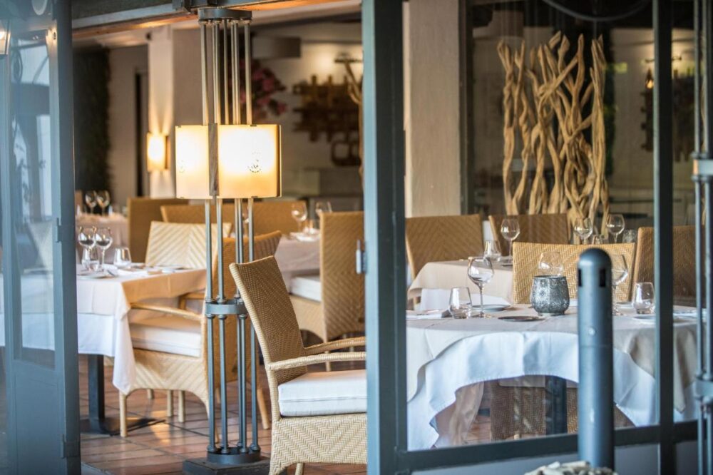 Salle à manger élégante avec tables dressées.