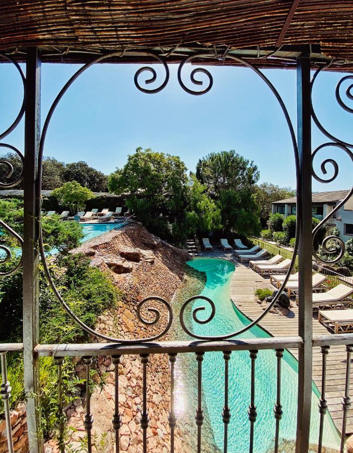 Piscine entourée de chaises longues et arbres.