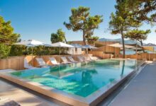 Piscine extérieure avec transats et parasols.