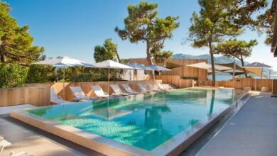 Piscine extérieure avec transats et parasols.