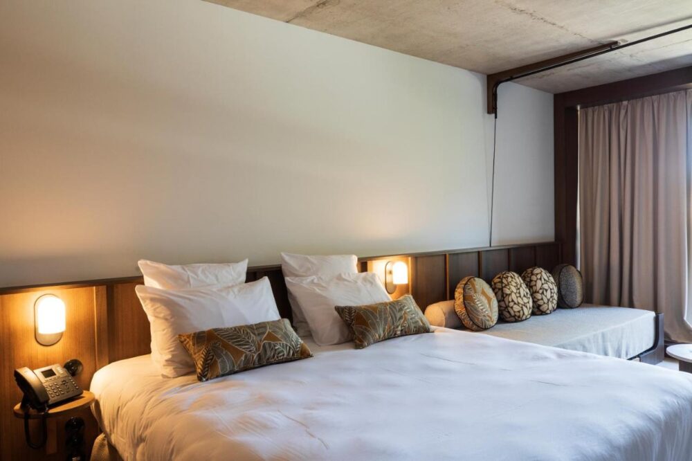 Chambre d'hôtel moderne avec lit et canapé.