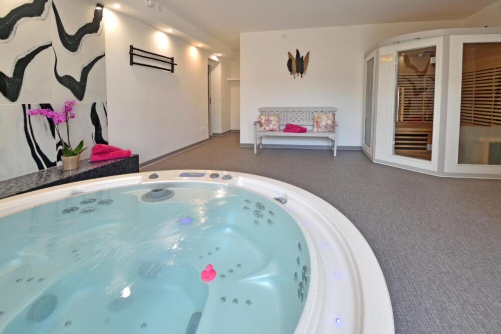 Salle avec jacuzzi et sauna moderne.